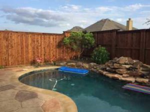 Backyard Pool Project Before Professional Landscaping in Prosper Texas backyard home. The new landscape design plans include replacing old mulch in bed areas with river rocks and old plants with new tropical landscape.